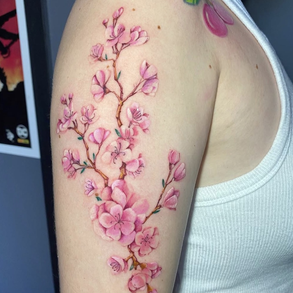 Tatuagem floral colorida em tons rosados por Ricardo Marinho
