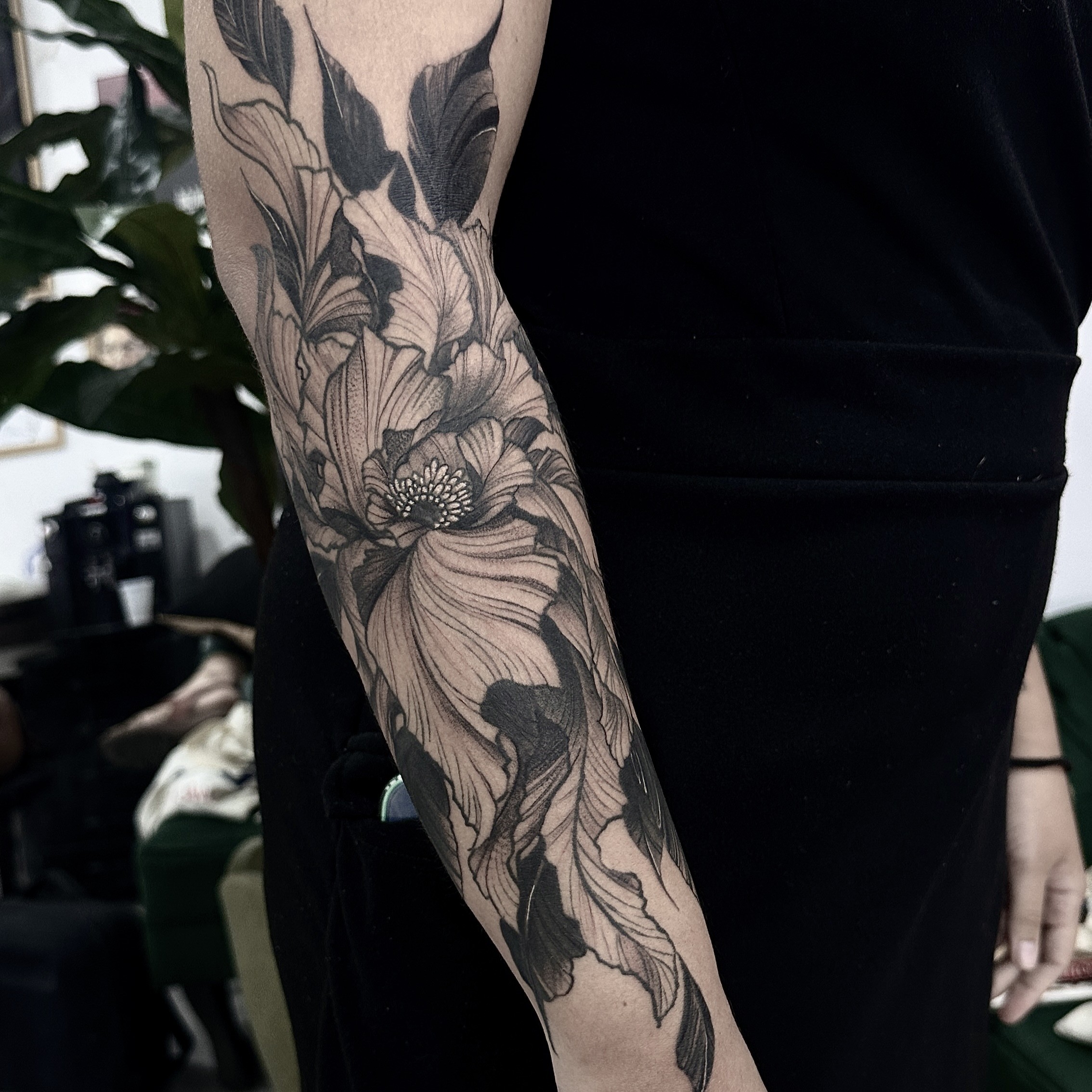 Tatuagem floral em preto e cinza com composição fechada por Ricardo Marinho