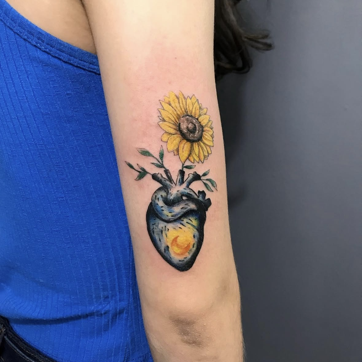Tatuagem colorida de coração anatômico com flores por Ricardo Marinho
