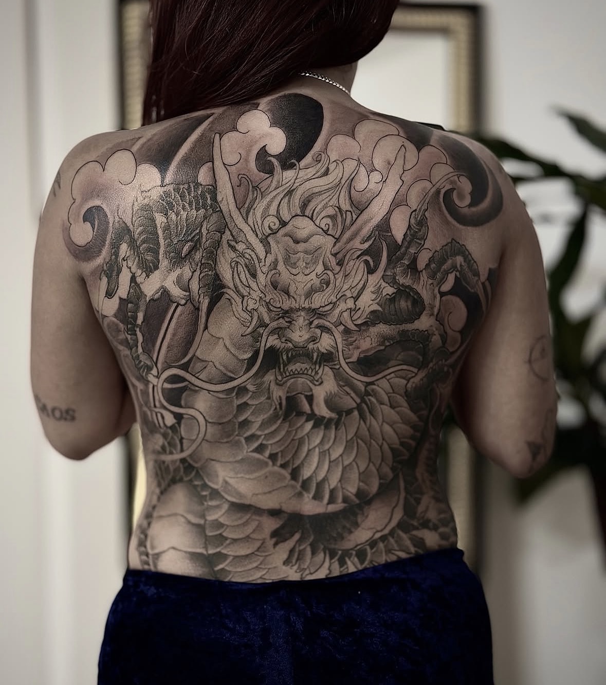 Tatuagem oriental de dragão com flores no peito por Ricardo Marinho