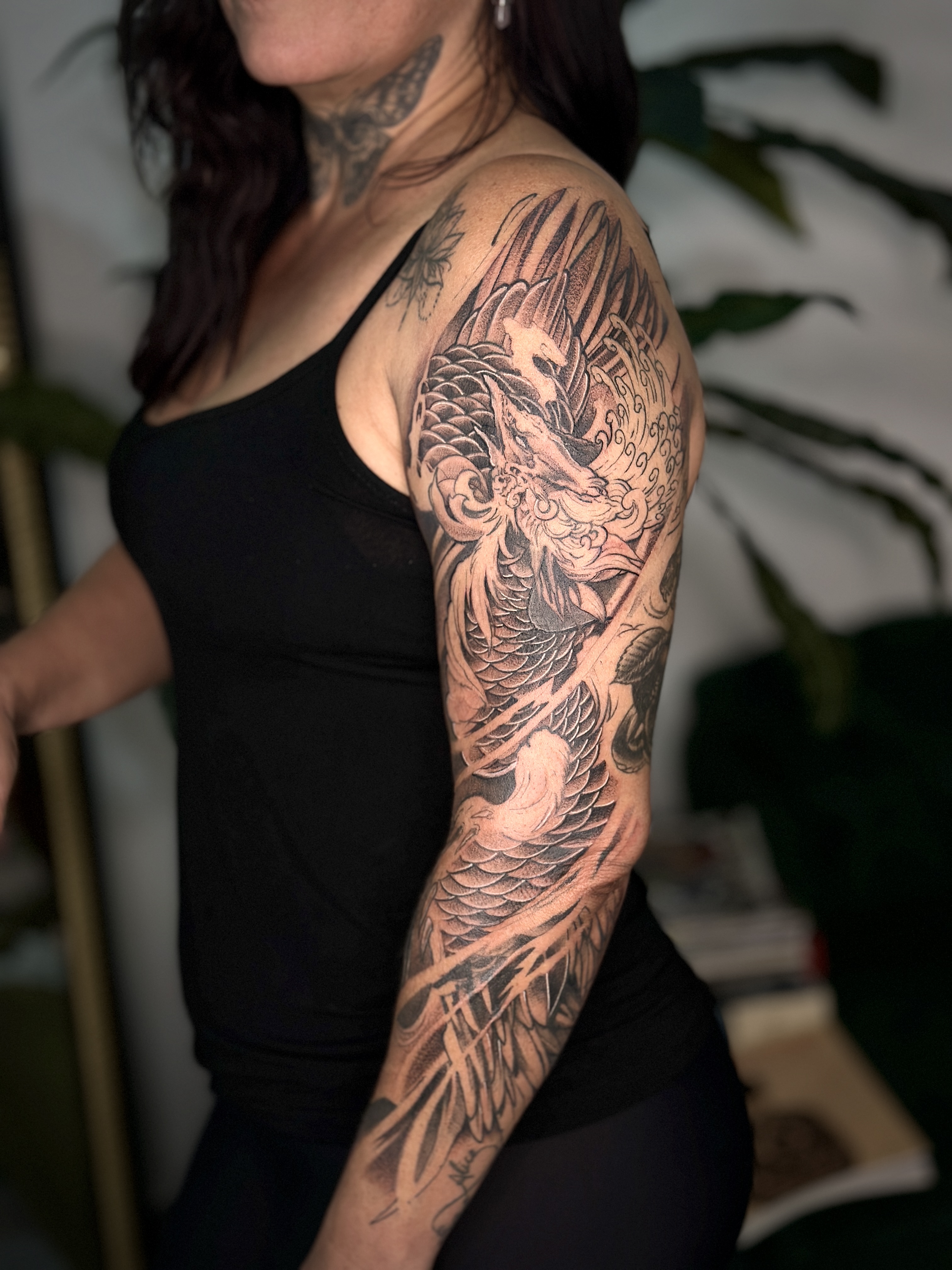 Tatuagem oriental fechando o braço com composição em preto e cinza por Ricardo Marinho